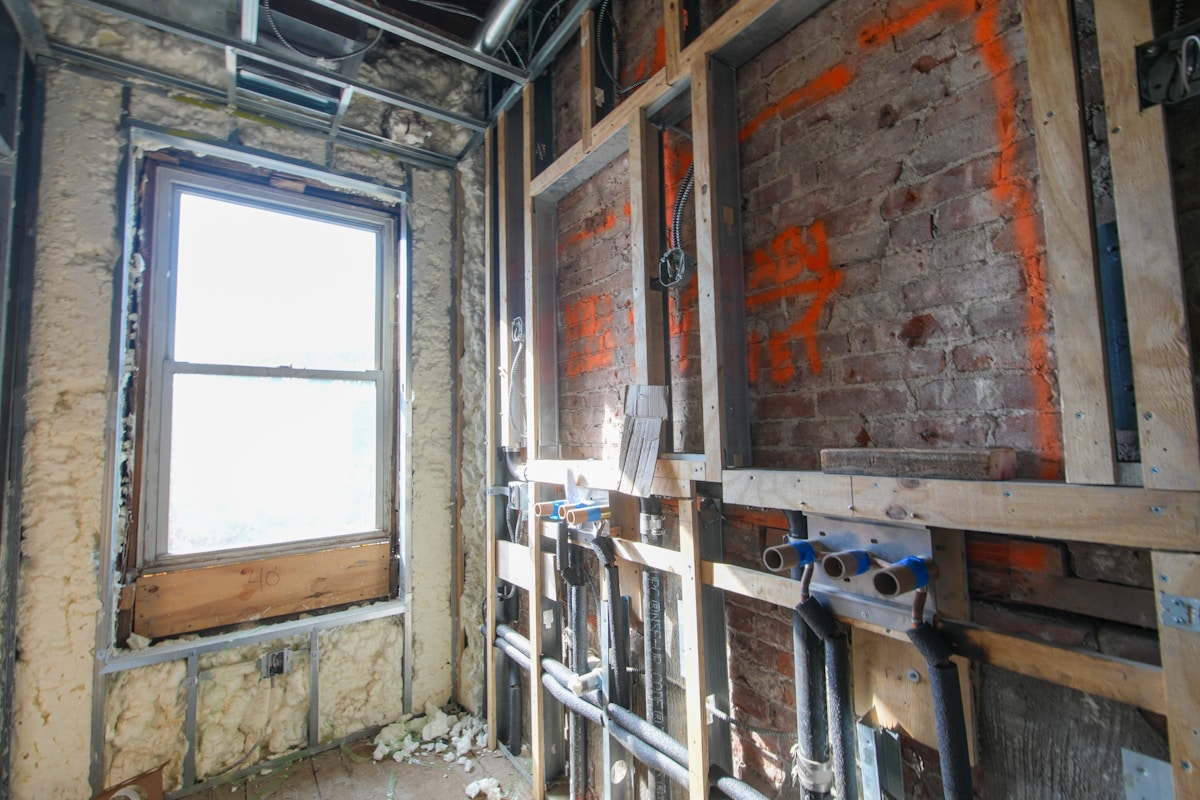 Exposed pipes and wiring after ceiling removal